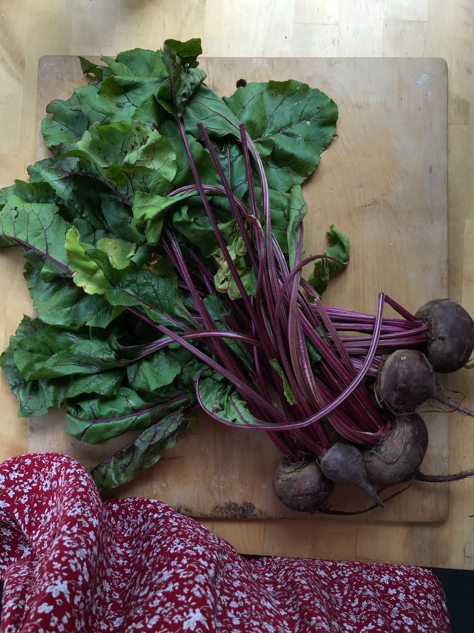 Bunch of red beets on cutting board.